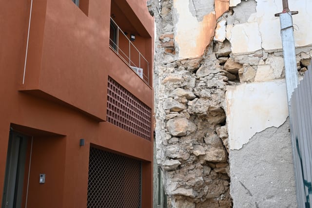 Cracked plaster and exposed brickwork on an old building wall