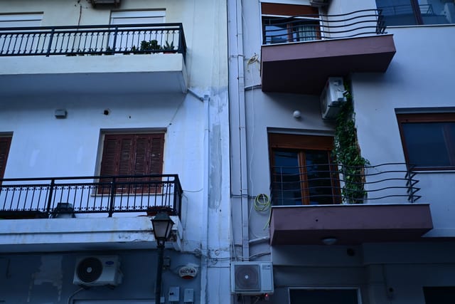 Fading mural on a wall partially obscured by a new air conditioning unit
