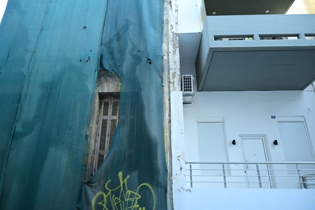 Empty clothesline on a weathered balcony overlooking a row of tourist lets