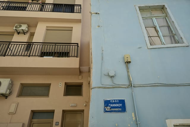 Political sticker and old posters on a doorframe next to a minimalist keybox
