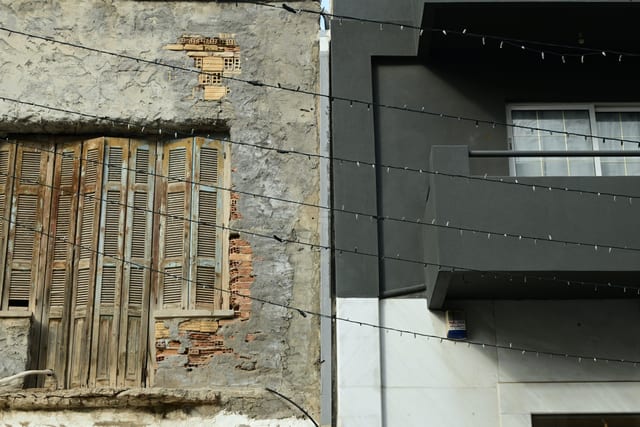 Street-level view of shop shutters beside a converted apartment entrance